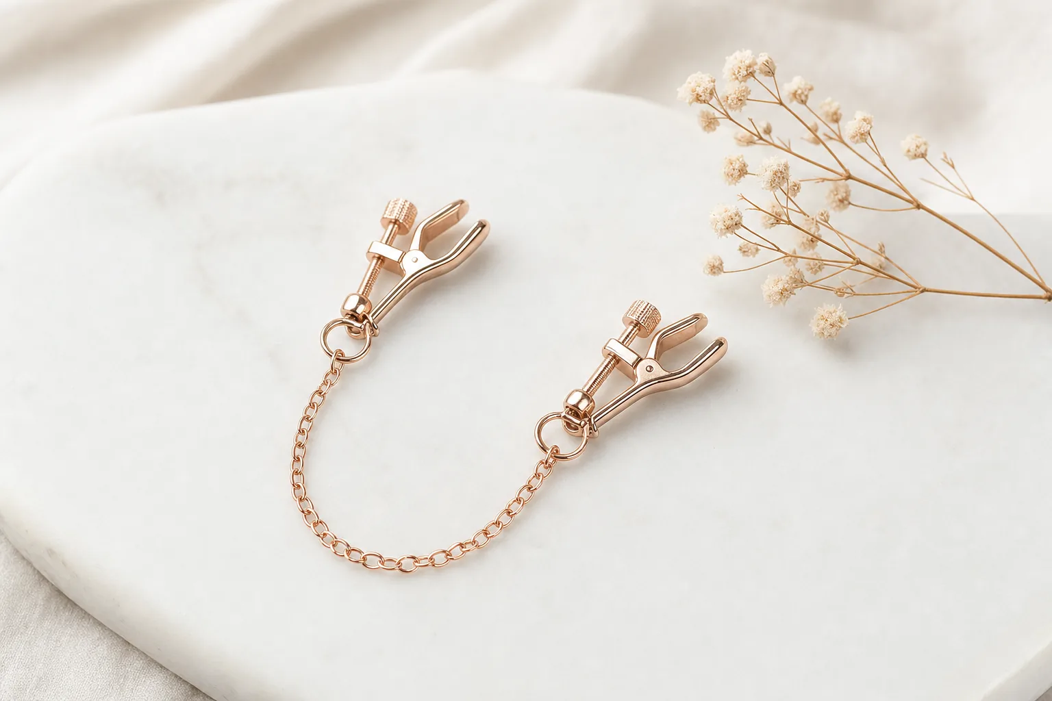 Adjustable nipple clamps displayed as retail products on a neutral surface, styled as an editorial flat-lay.